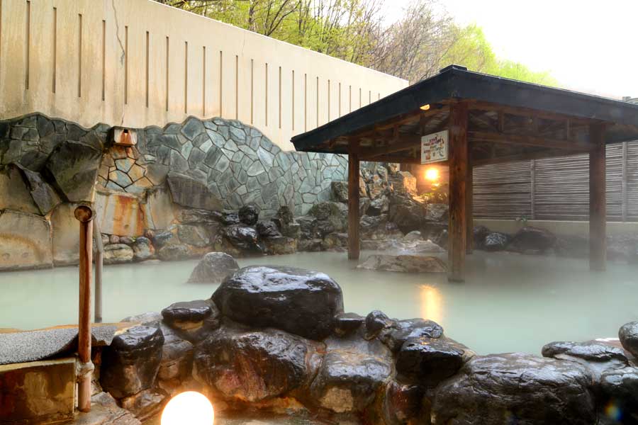 登別万世閣の湯煙が立ち上る登別温泉の広々とした露天風呂